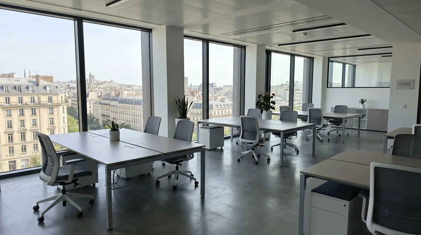 Intérieur d'un espace de coworking moderne et lumineux avec grandes baies vitrées donnant sur une ville française, mobilier contemporain épuré et lignes architecturales nettes